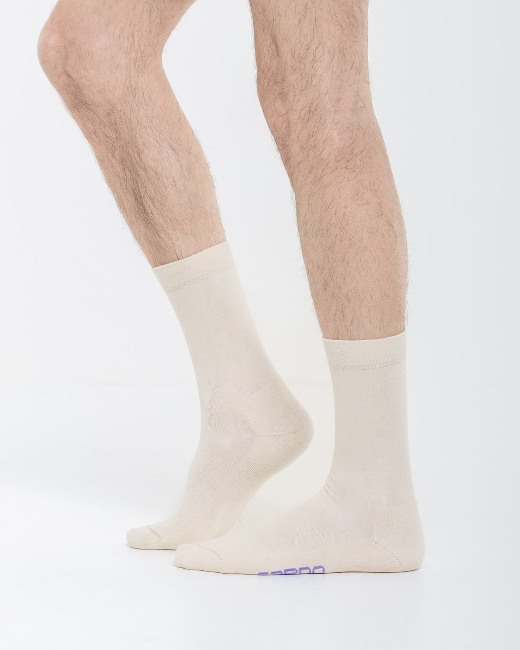 Cardo Radura Field Half Calf socks in ecru, side view on a model against a white background.