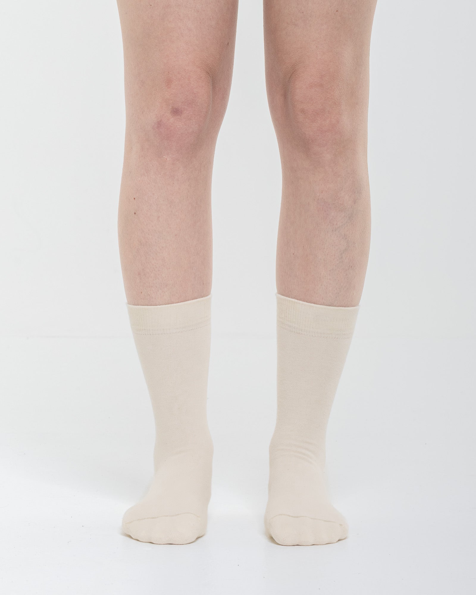 Cardo Radura Field Half Calf socks in ecru, front view on a model against a white background.