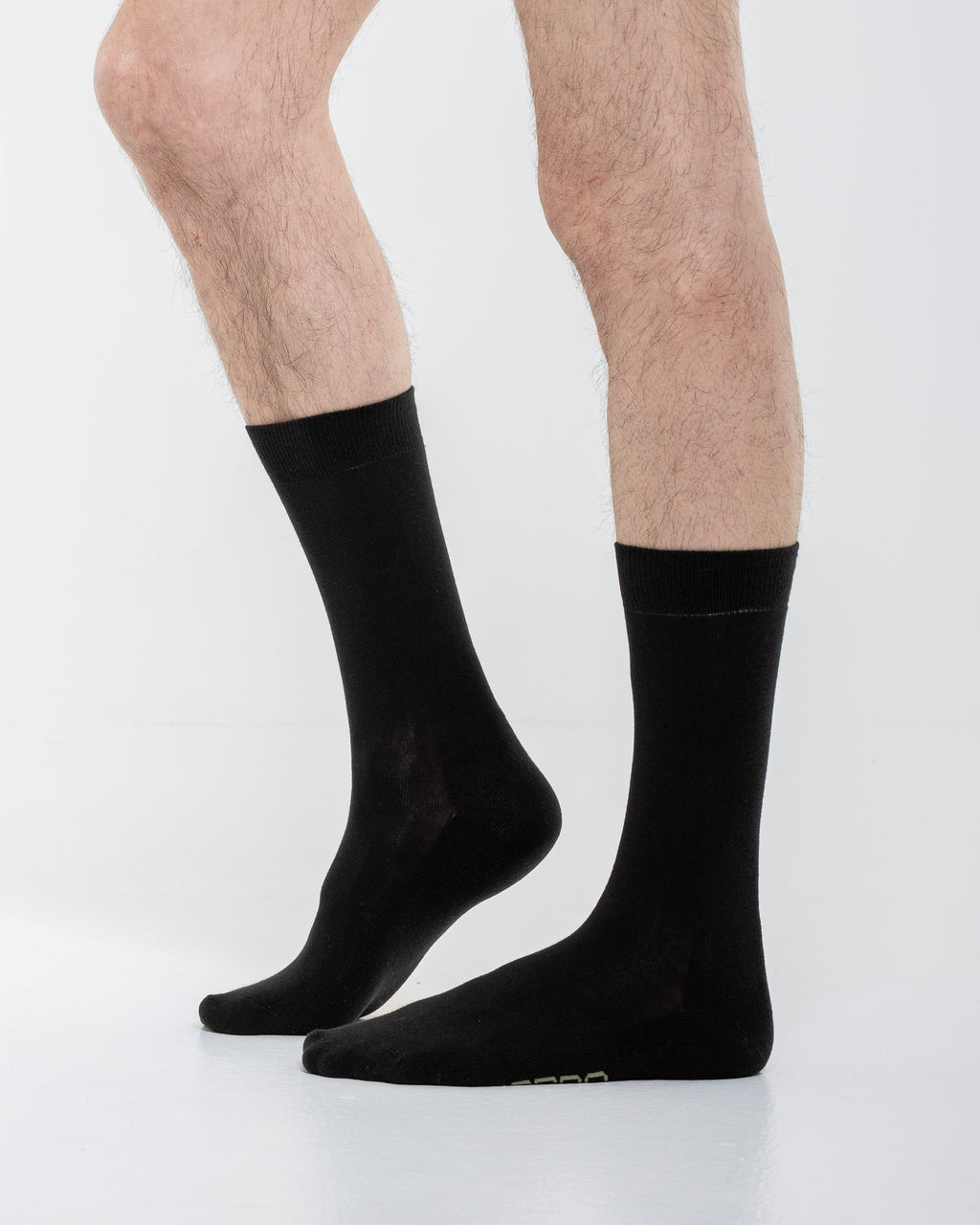Cardo Radura Field Half Calf socks in black, side view on a model against a white background.