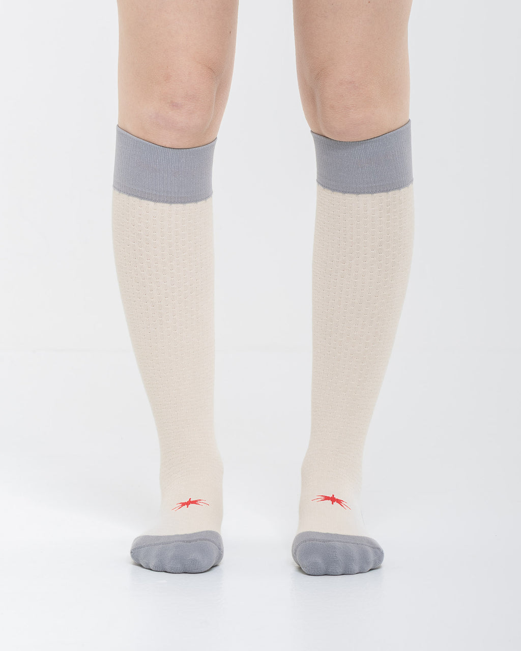 Cardo Radura Strata Lite Knee High socks in Stone, front view showing the red embroidered star detail.
